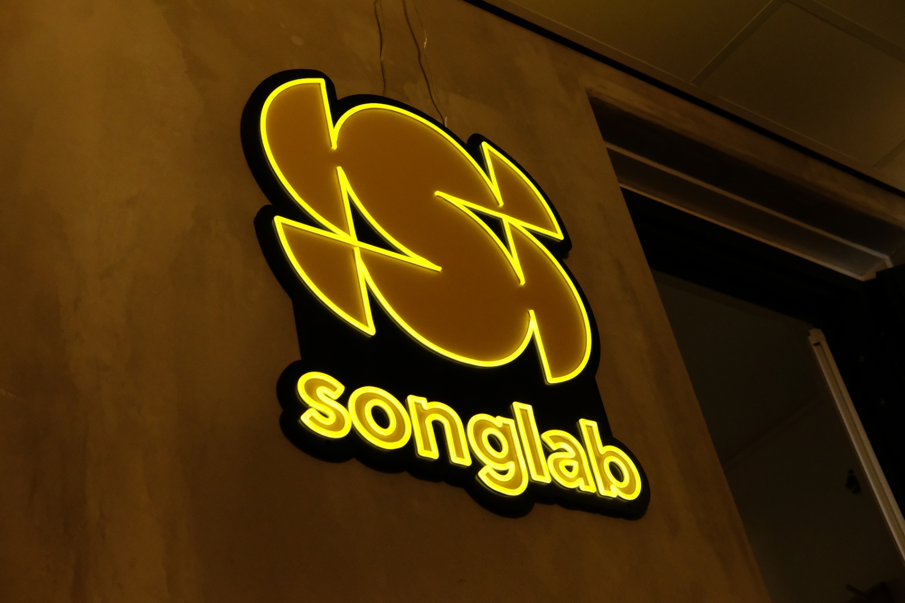 Songlab neonlogo aan de studiomuur