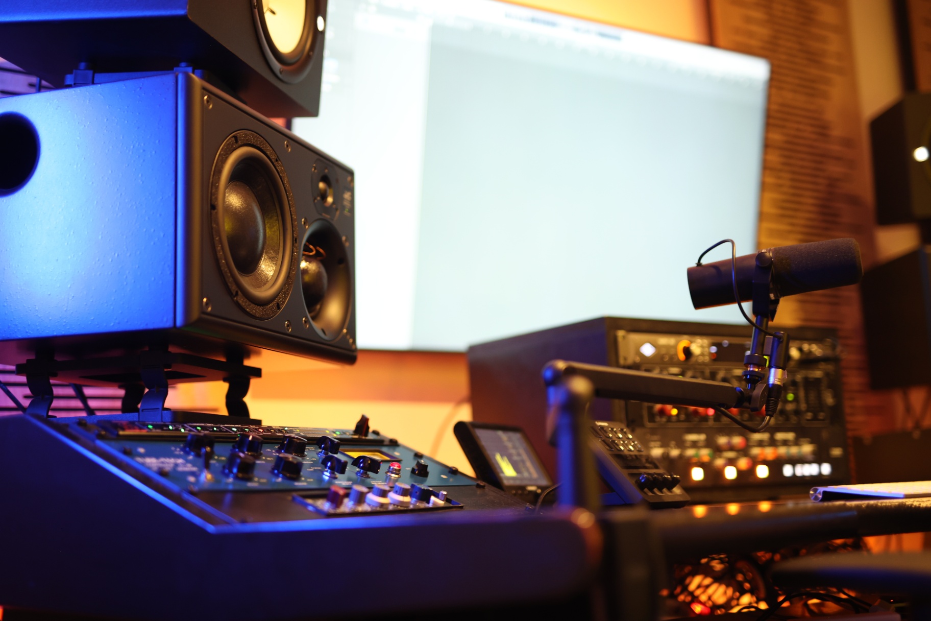 Control room met monitoren, mixerdesk en broadcast-microfoon